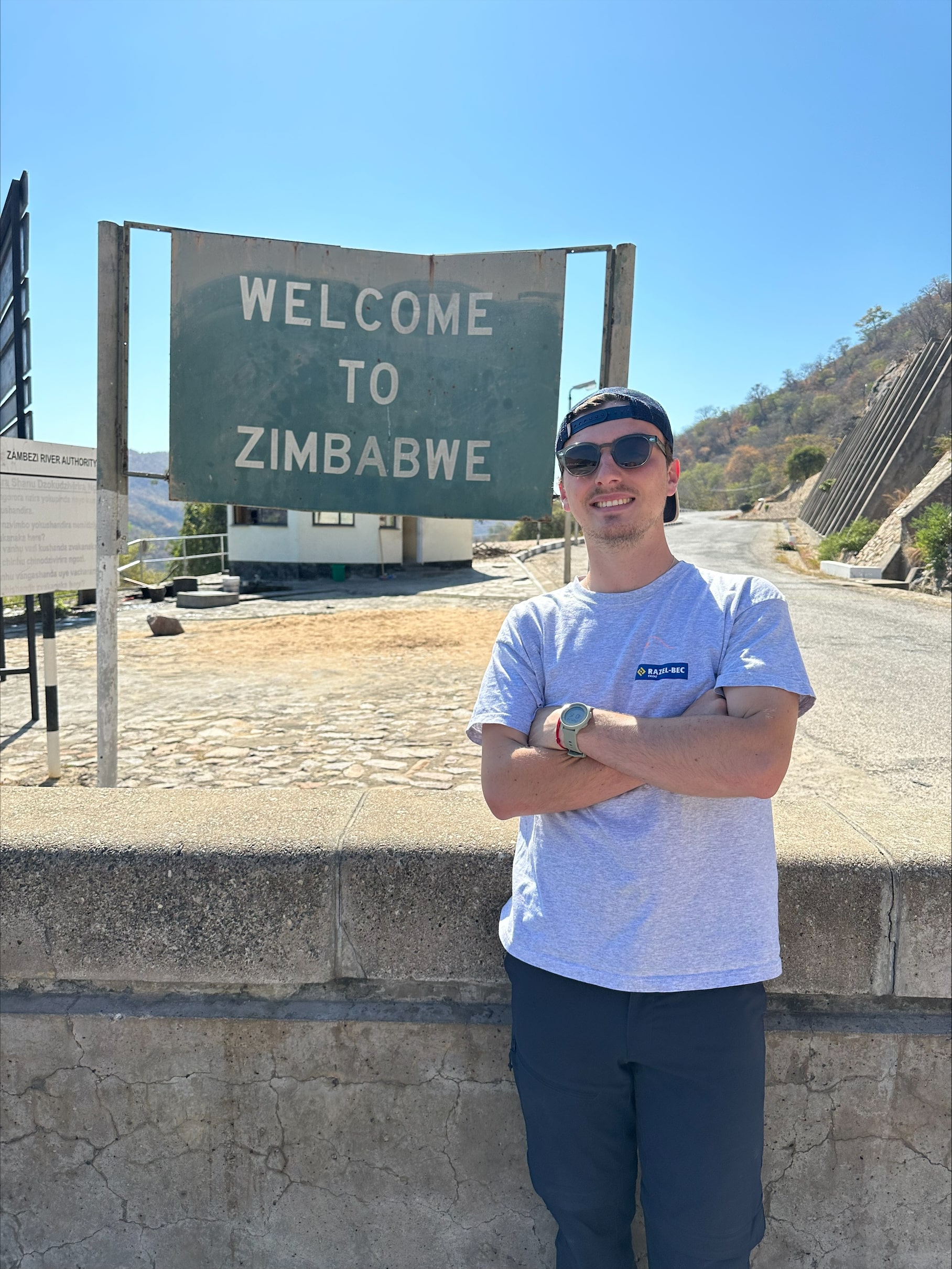 Photos de David Rousseau devant le panneau "Welcome to Zimbabwe"